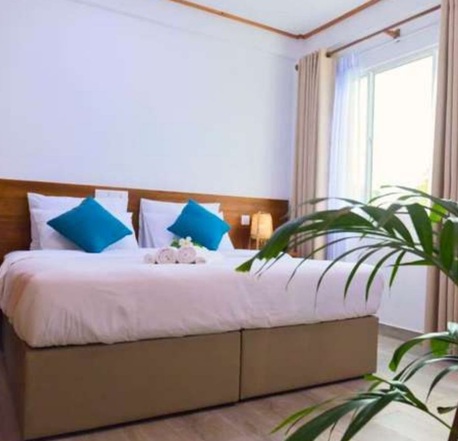 Doppelzimmer mit türkisfarbenen Kissen