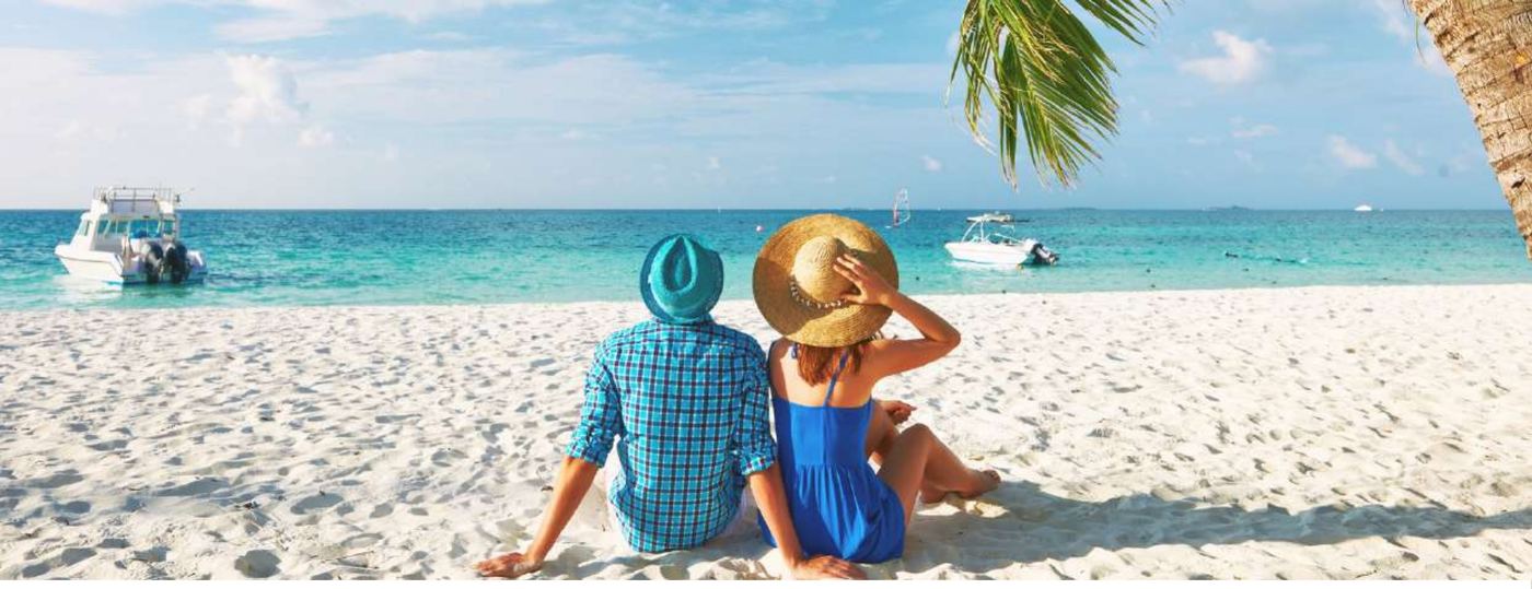 Paar sitzt am Strand des Baa Atolls